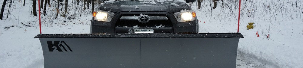 Detail K2 snow plow mounted on toyota SUV in snow.