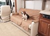 Dog sitting on canine covers sofa protector in RV living room.