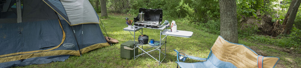 Campsite with tent, camp kitchen setup, and camping chair.