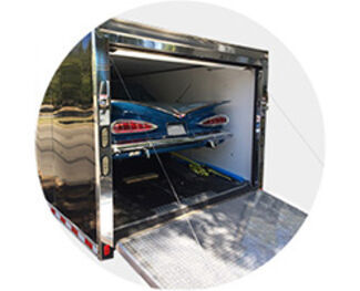 silver enclosed trailer with car in back. 
