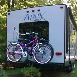 Bicycle mounted on bicycle carrier at back of travel trailer