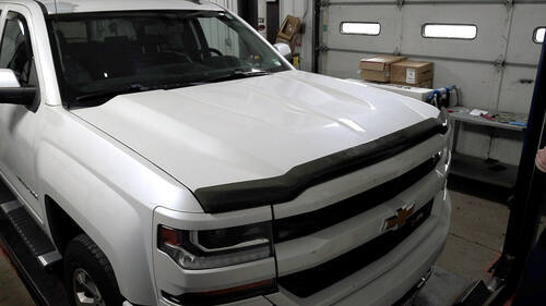 Black Flint Hill Goods bug deflector installed on a white Chevrolet truck