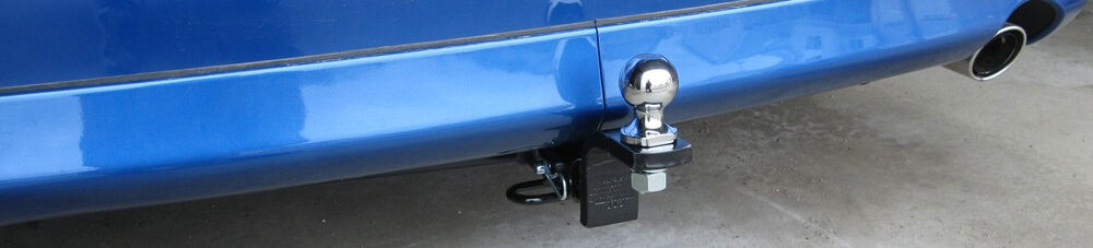 Trailer hitch ball mounted on blue vehicle.