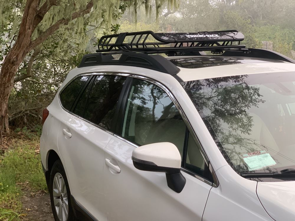black rhino rack kayak carriers on a silver roof rack on the roof of a dark truck
