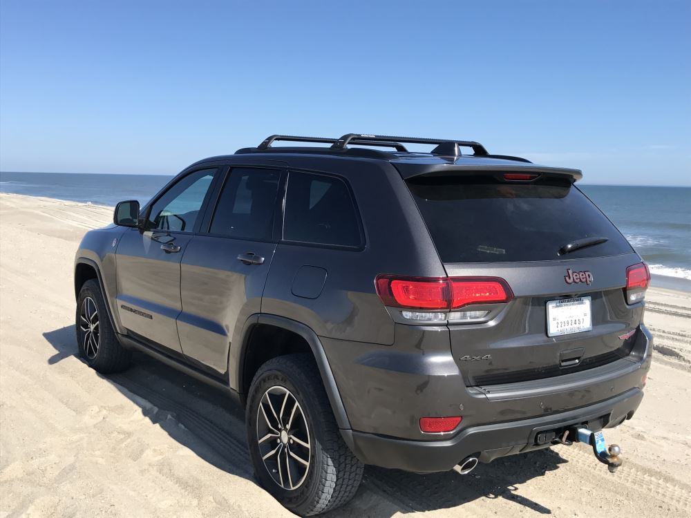 black rhino rack kayak carriers on a silver roof rack on the roof of a dark truck
