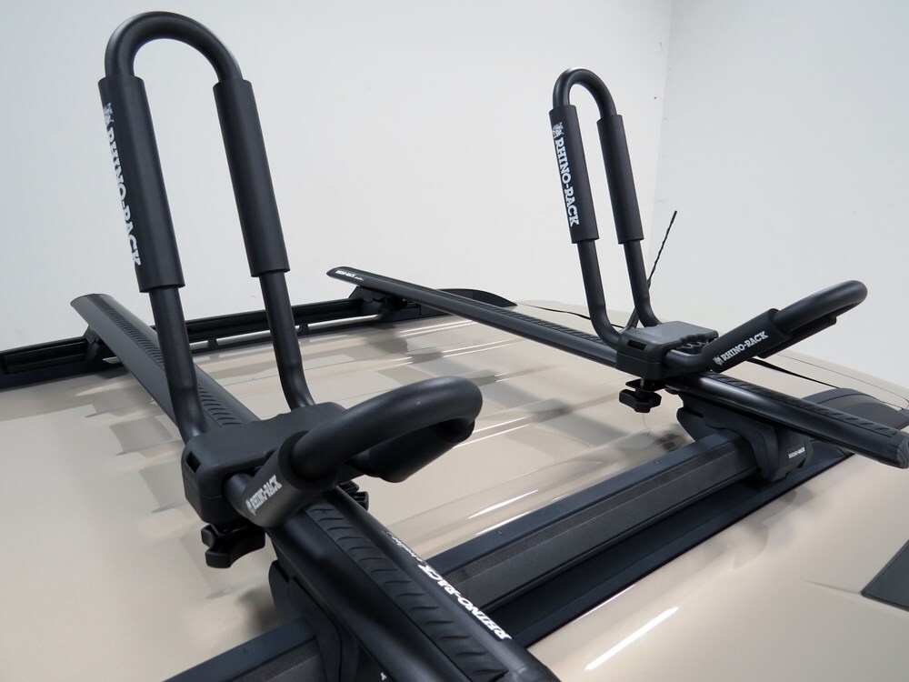 black rhino rack kayak carriers on a silver roof rack on the roof of a dark truck