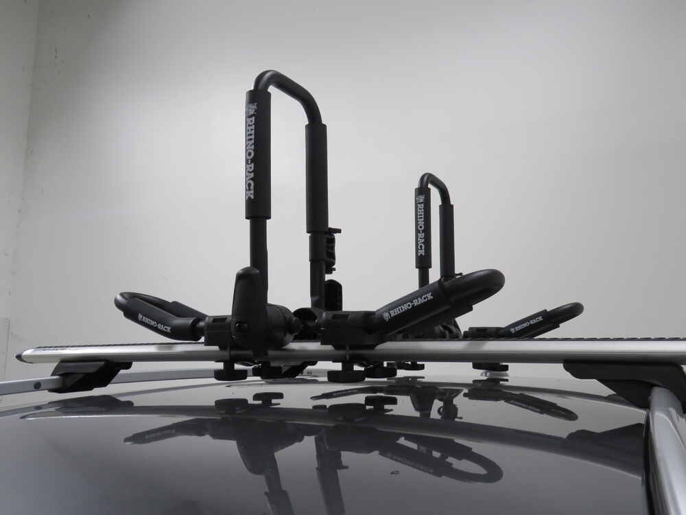 black rhino rack kayak carriers on a silver roof rack on the roof of a dark truck