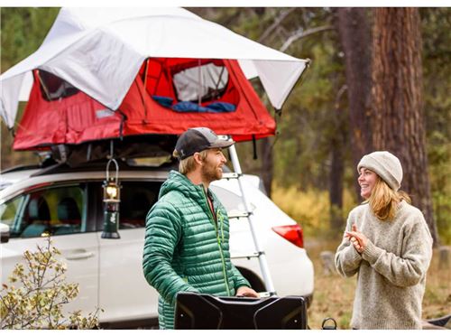 Couple in front of car with tent on top