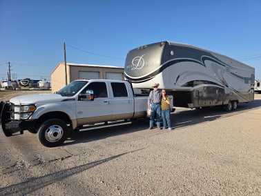 Man and Woman standing outside 5th wheel.