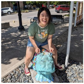 Peggy sitting on a hippo statue.