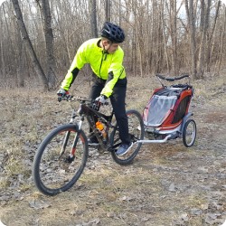 Man on bike pulling children's trailer. 