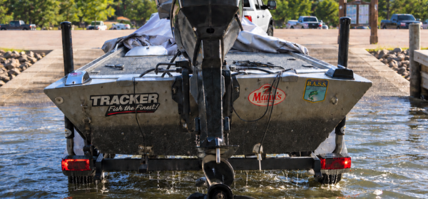 Boat being loading on a trailer at a dock. 