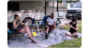 group sitting outside RV. 