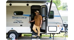 Man standing on steps coming out of RV. 