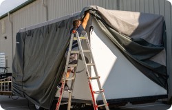 man putting cover on RV. 