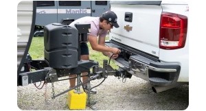 Man plugging in wiring from trailer to truck. 