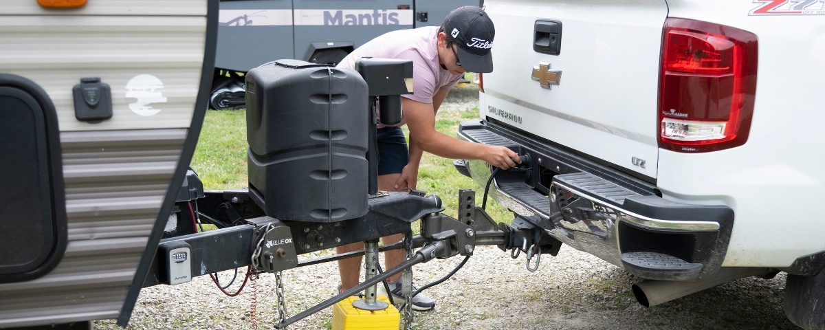 Man Hooking Up Travel Trailer to Truck