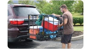 man loading cooler into enclosed cargo carrier.
