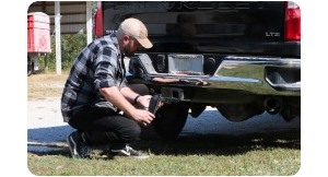Man installing ball mount in trailer hitch.